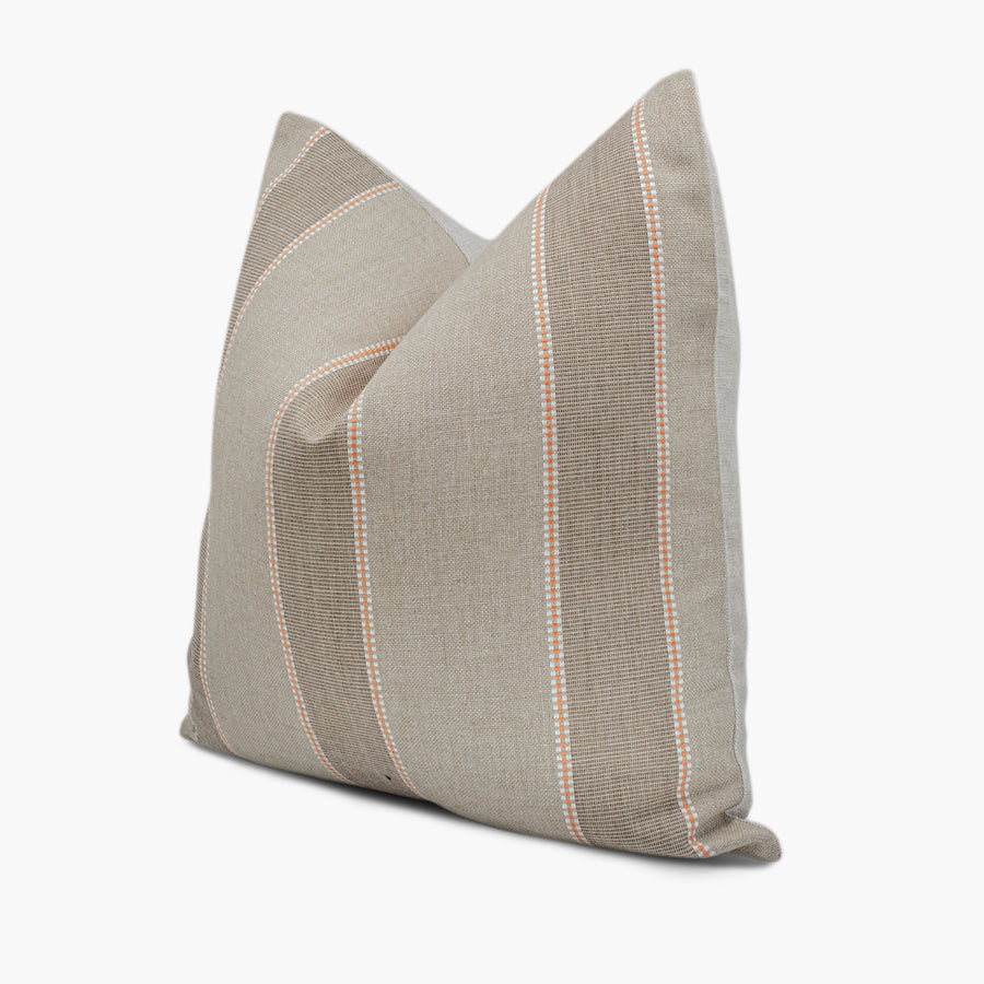 Side view of striped throw pillow in orange and beige