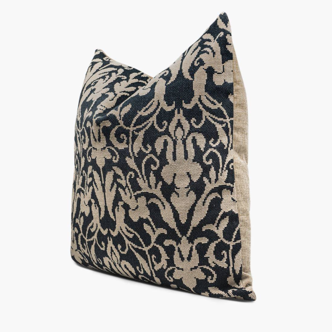 Side view of a decorative throw pillow with a black and beige damask pattern