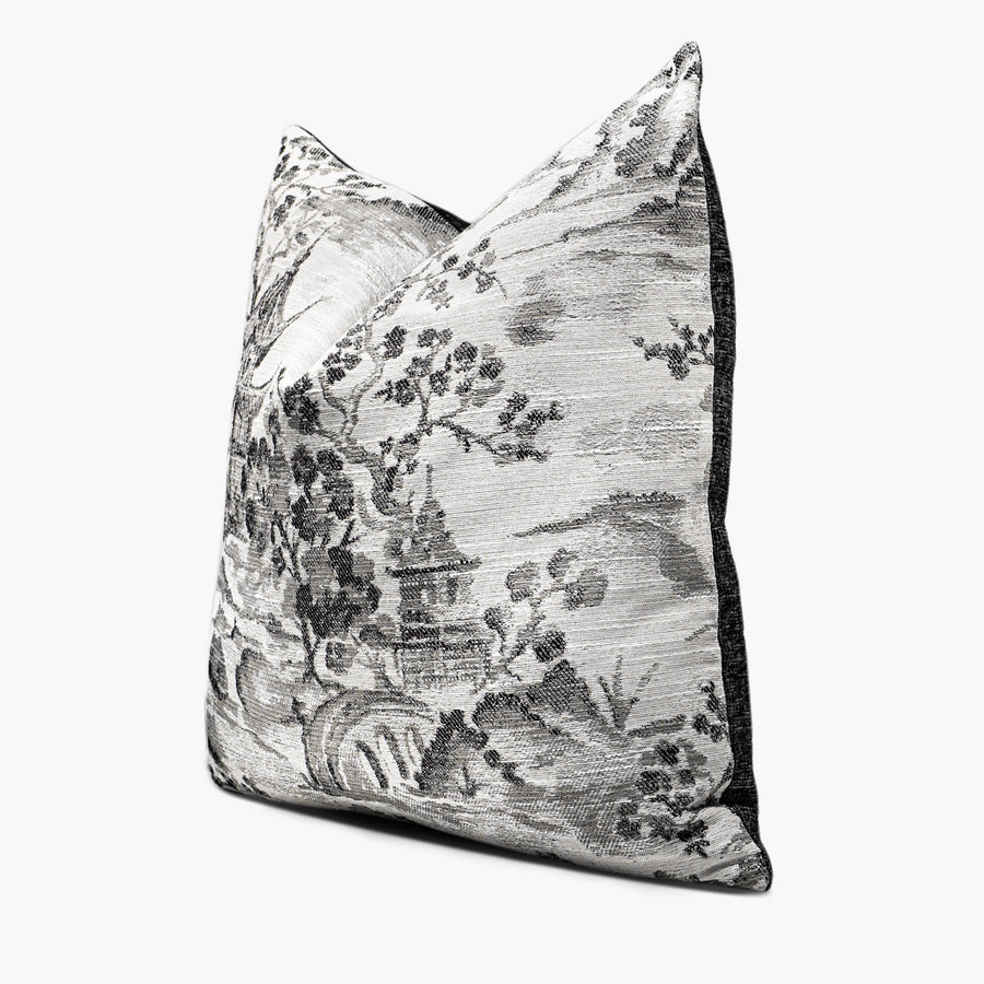 Side view of a decorative throw pillow with a black and white chinoiserie pattern