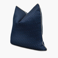 Side view of dark blue throw pillow with a repeating diamond pattern