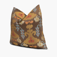 Quarter view of an ikat throw pillow in brown and gold