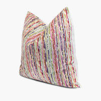 Quarter view of a velvet throw pillow with thin stripes in candy colors