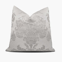 A silver gray throw pillow with a large-scale damask motif sits against a white background.