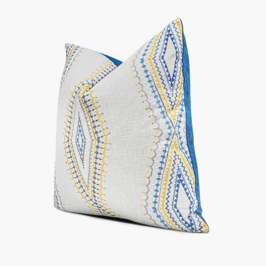 Side view of embroidered throw pillow with diamond medallion motif in blue, gold, and silver