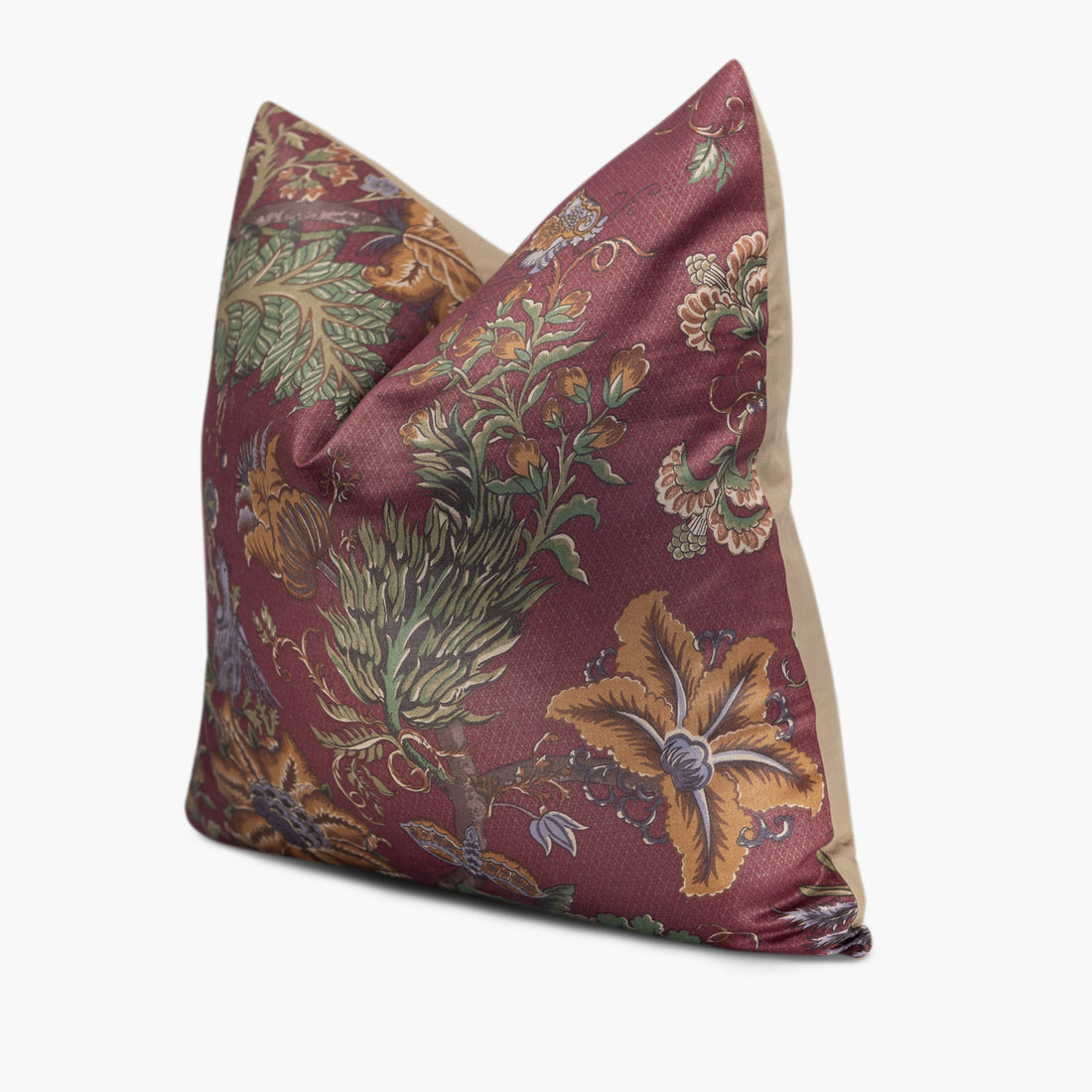 Side view of burgundy red throw pillow with a floral and exotic bird motif