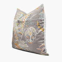 Side view of a warm gray linen throw pillow with an exotic floral motif in yellow, orange, and light aqua blue