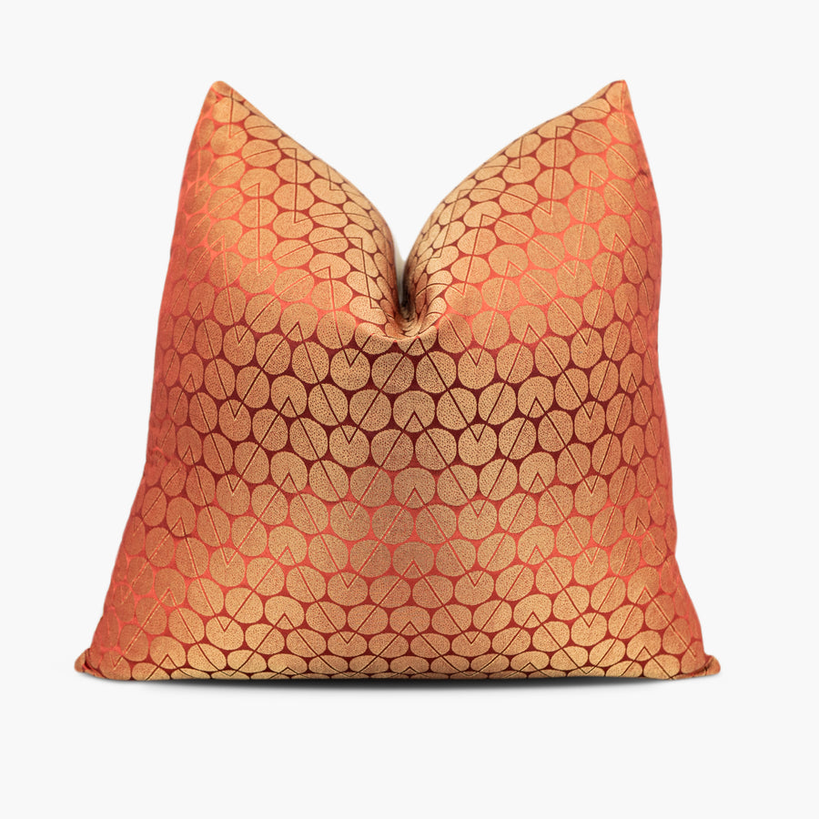 Geometric throw pillow with a circle and zigzag motif in iridescent gold and orange