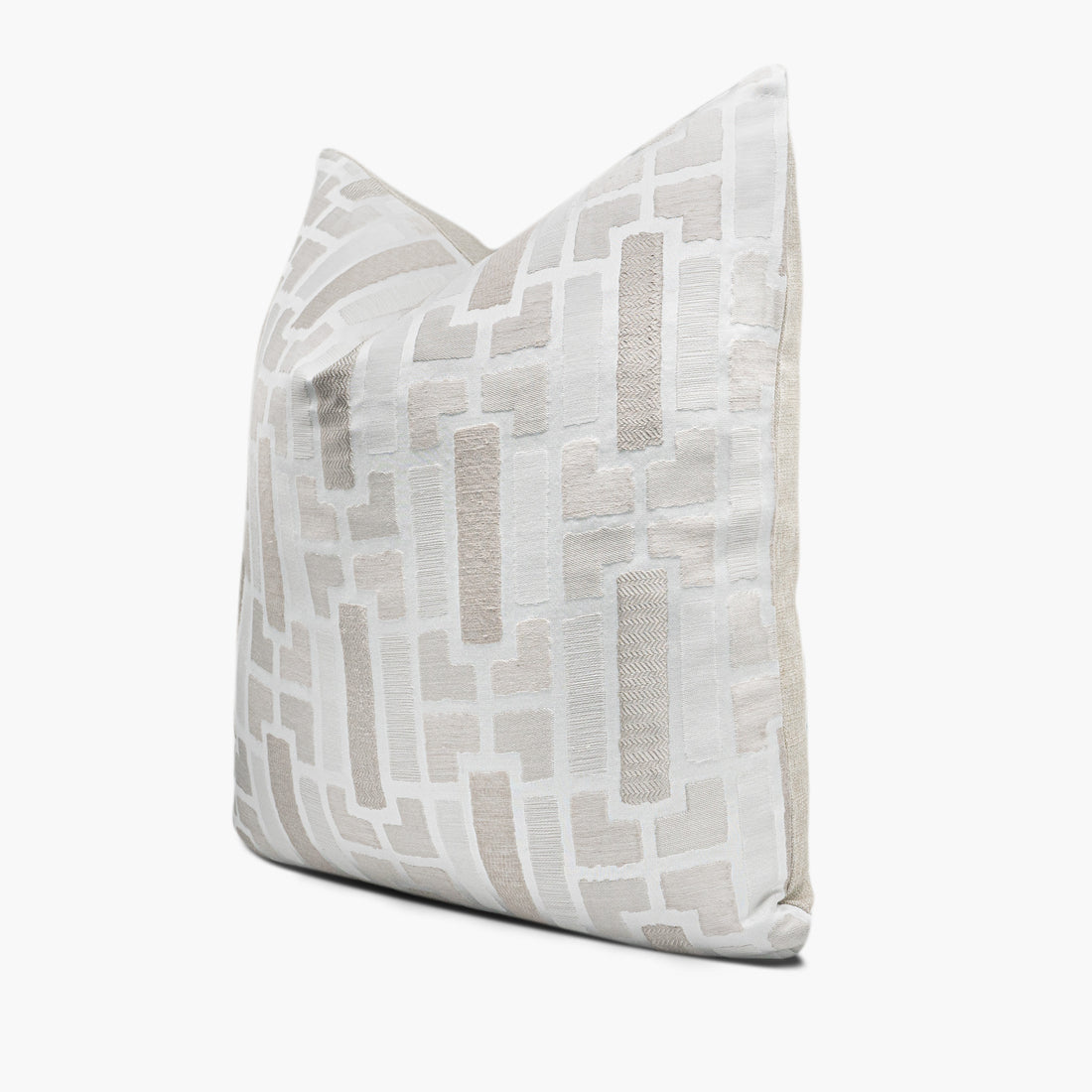 Side view of geometric throw pillow cushion in shades of cream, off-white, and natural