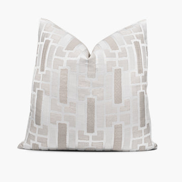 Geometric throw pillow cushion in shades of cream, off-white, and natural