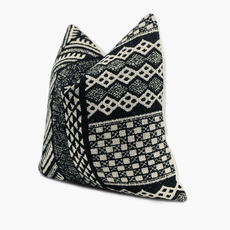 Side view of black and white throw pillow with a geometric tribal pattern