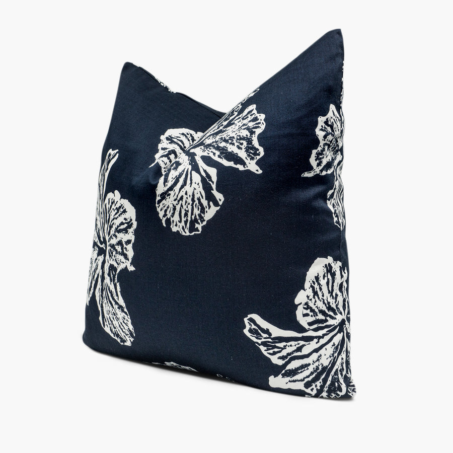 Side view of indigo blue throw pillow cushion with white hibiscus floral motif