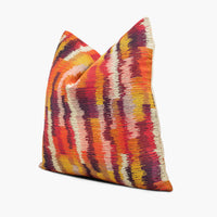 Side view of ikat flame stitch throw pillow in red, orange, yellow, and purple