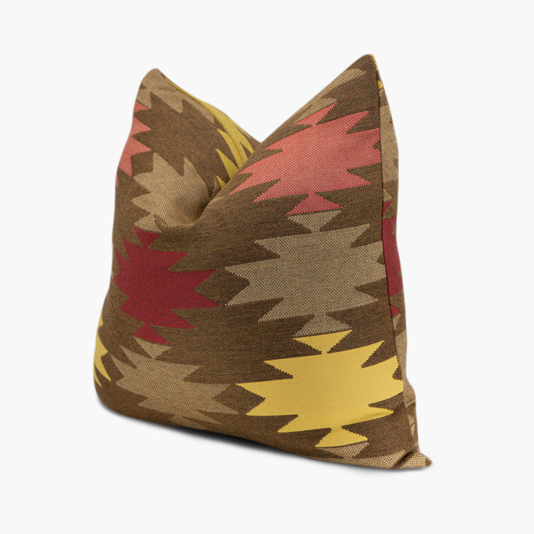 Quarter view of a brown outdoor throw pillow with red and yellow geometric shapes