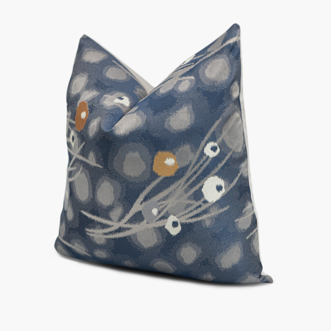 Quarter view of a blue and gray throw pillow with an abstract dandelion motif