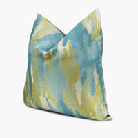 Quarter view of a turquoise blue and citron yellow throw pillow with an abstract watercolor motif