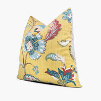 Side view of yellow floral throw pillow with blue and red flowers